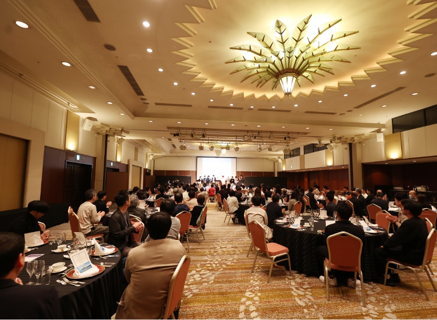 パーティ会場で着席している大勢の人の後ろ姿