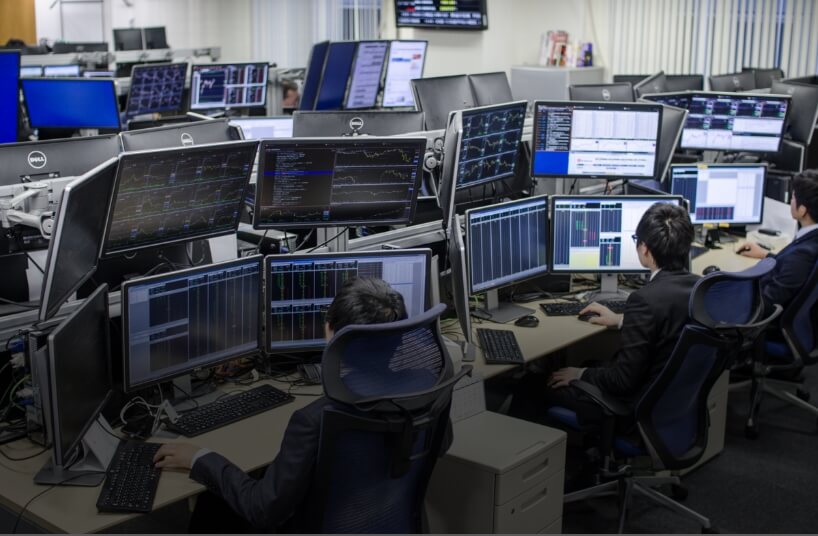 複数モニターで作業する2人の男性