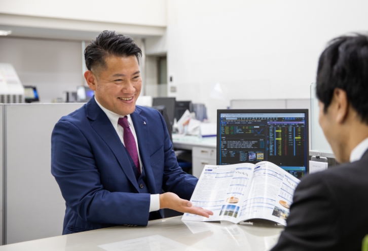 資料を説明する笑顔の男性営業