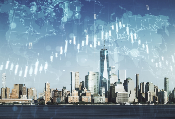 高層ビル群の上に、株価チャートが重ねて表示されたイメージ