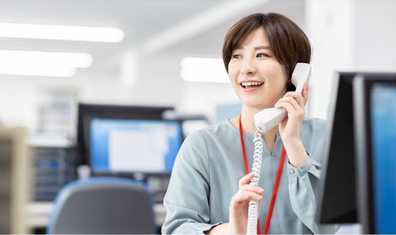 笑顔で電話対応中の女性