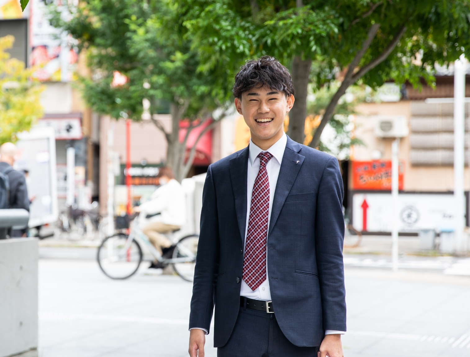 赤ネクタイで笑顔の営業職男性社員