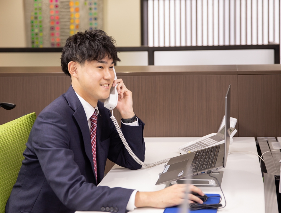 子機で通話中のスーツ姿の男性営業社員