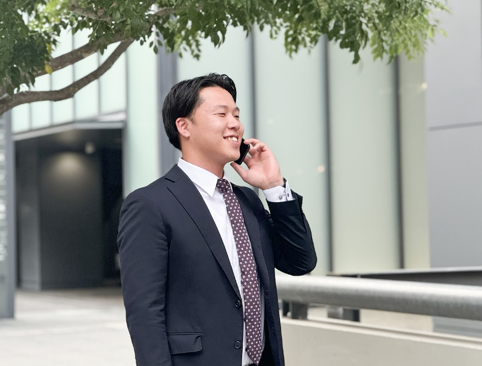 スマホで連絡を取る営業職男性社員