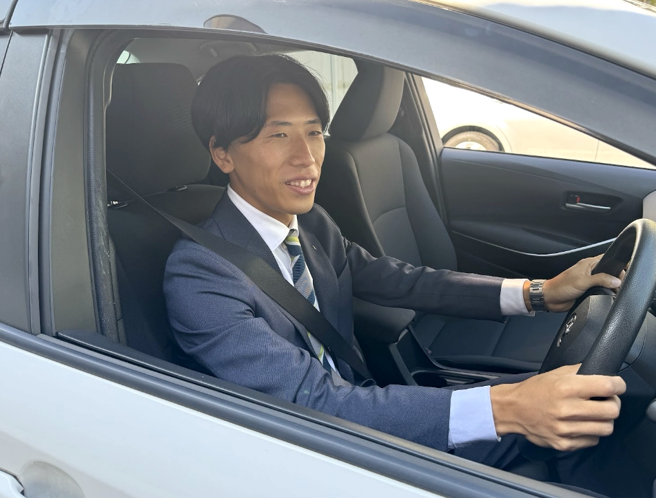 車を運転するスーツ姿の営業職の男性