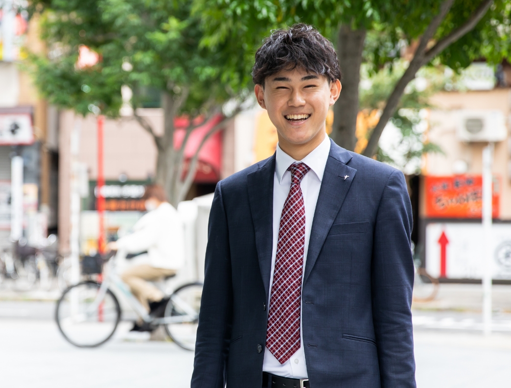 赤ネクタイで笑顔の営業職男性社員